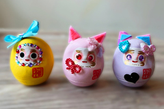 はっぴーだるまが3個映っています。スパンコールでキラキラしていて、カラフルです。